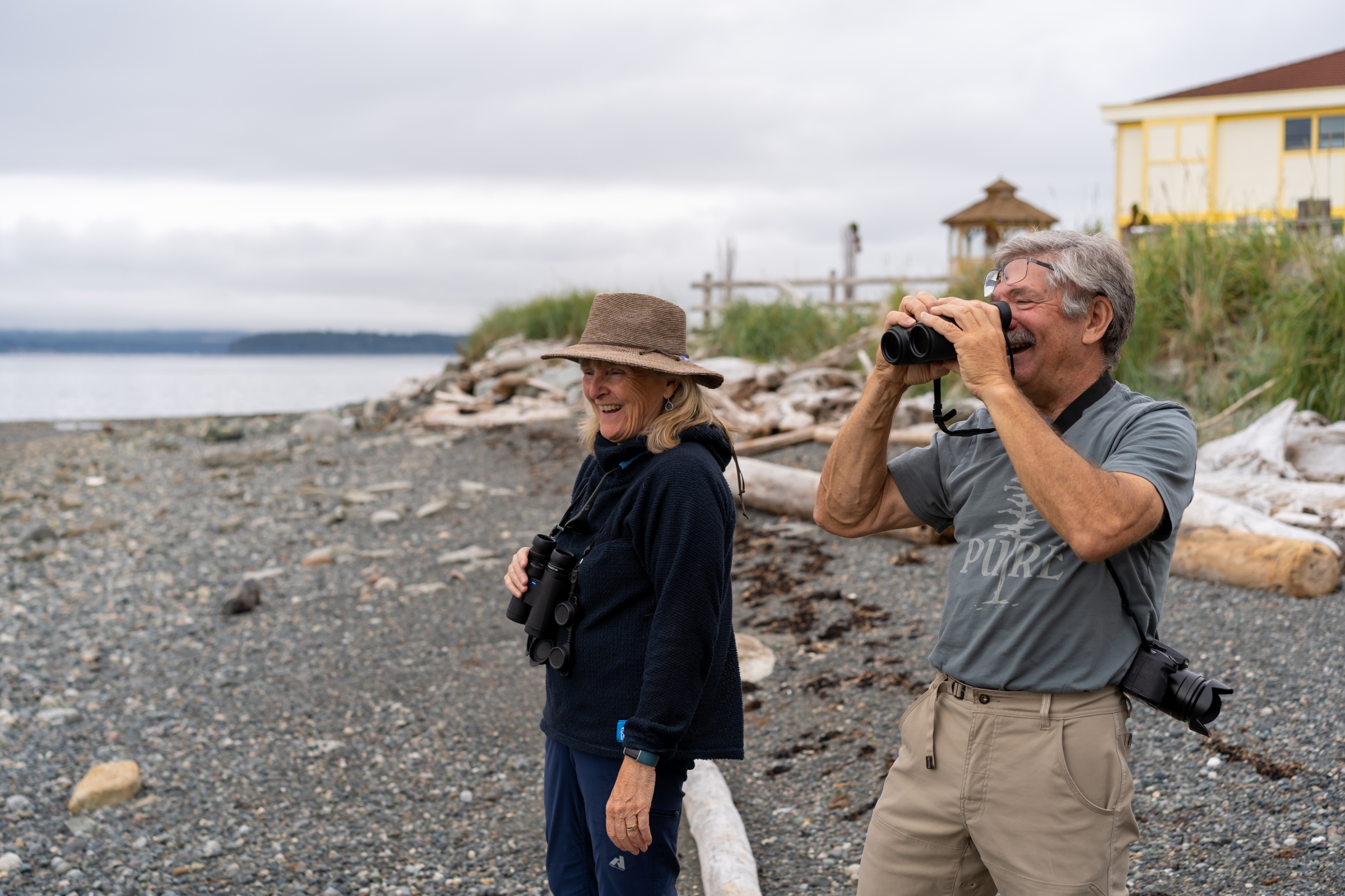 Two people on a beach bird watching